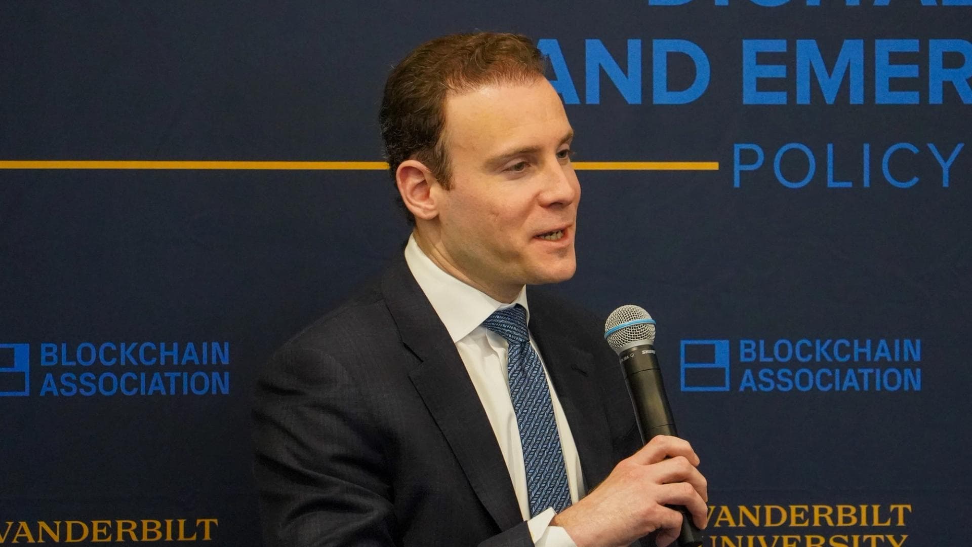Un orador se dirige a la audiencia en un evento relacionado con blockchain, un sector en constante evolución regulatoria.