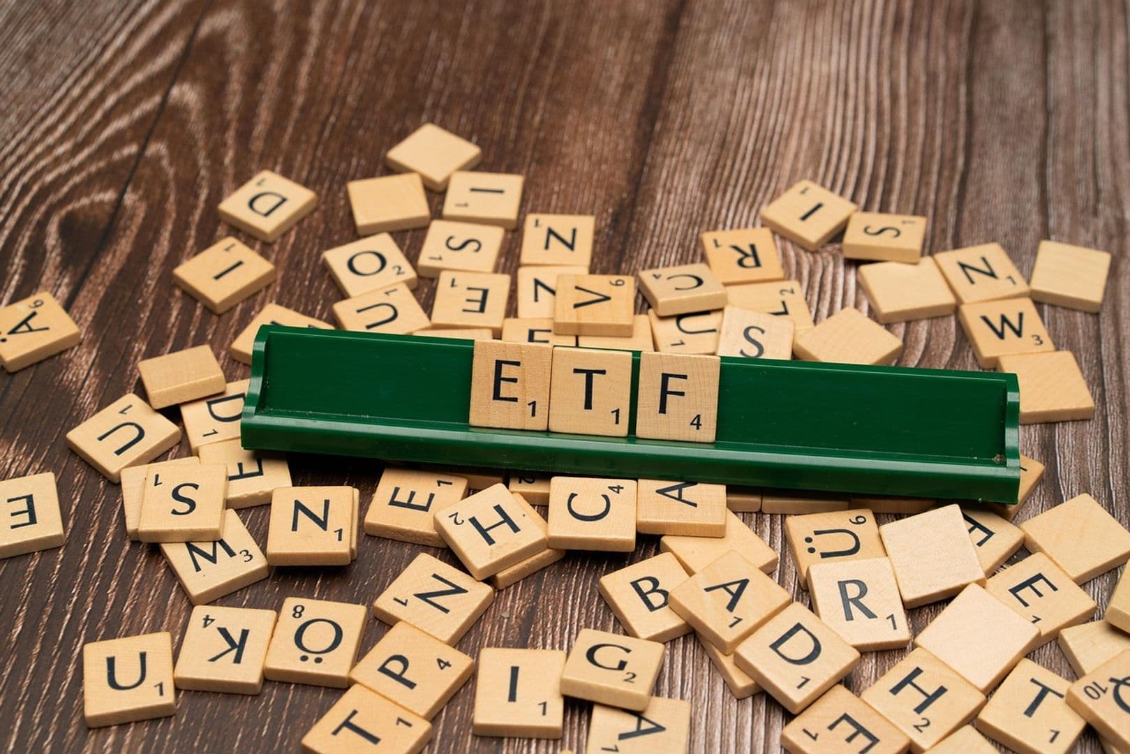 Las fichas de Scrabble deletrean 'ETF', simbolizando los fondos cotizados en bolsa de Bitcoin que han registrado un notable incremento en las entradas de capital.